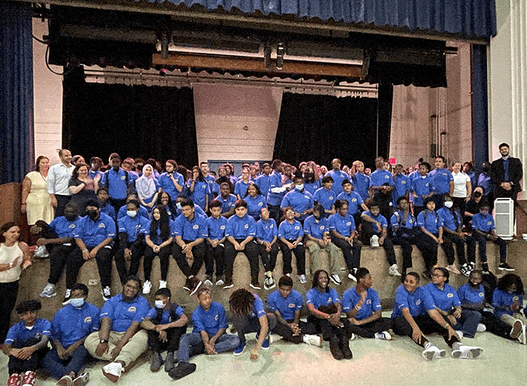 Students and staff lined up in front of and on stage