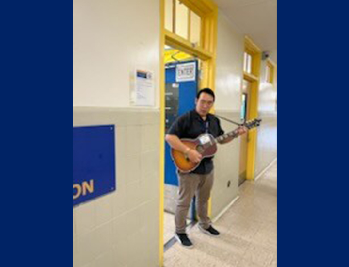 Teacher in the hallway playing guitar